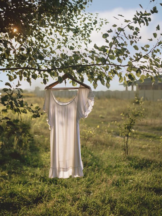 White ruffle summer dress on a hanger outdoors